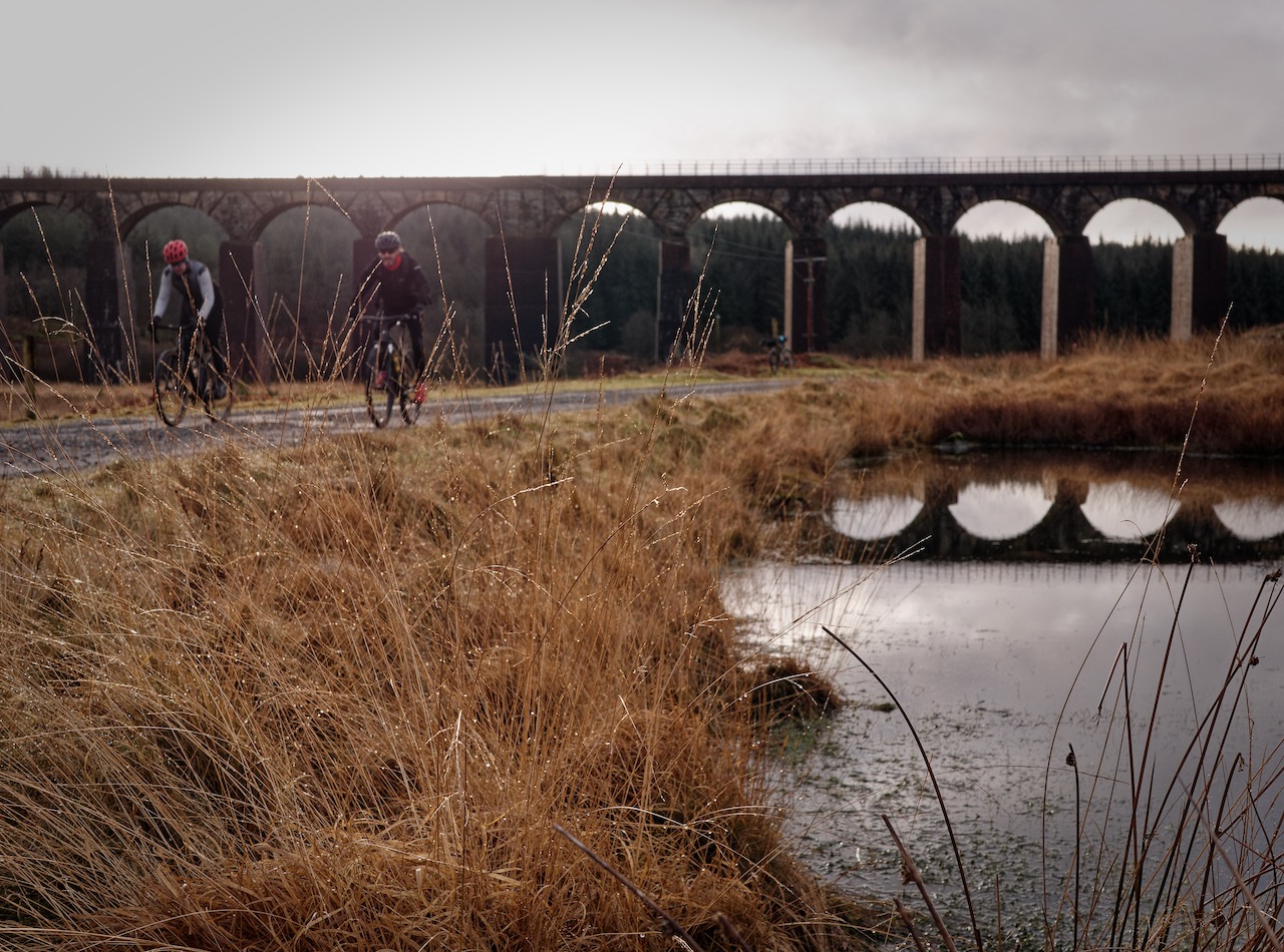 two cyclists passing near viaduct